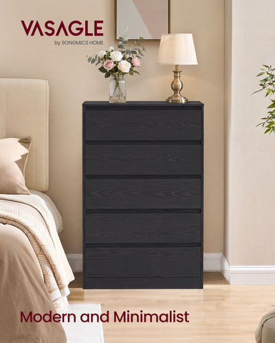 Black 5 drawer chest beside a bed with a lamp and flowers on top