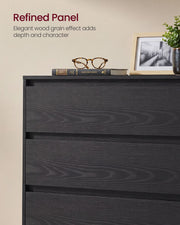 Close-up of the black wood grain drawer fronts with glasses and a picture frame on top