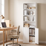 White bookcase beside a wooden desk in a home office with one cabinet door standing open