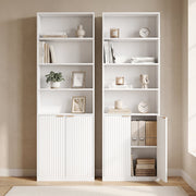 Two white bookcases side by side, one with a cabinet door open showing box files