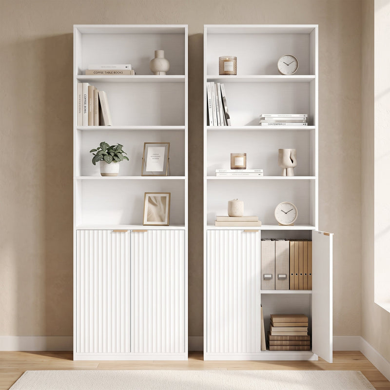 Two white bookcases side by side, one with a cabinet door open showing box files
