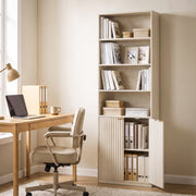 Oak bookcase styled in a home office beside a desk and chair