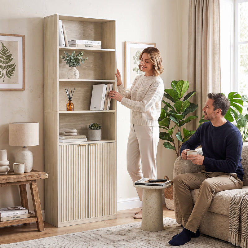 Couple styling the oak bookcase together in a bright living room