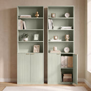 Two bookcases side by side, one with the cabinet door open showing files and books
