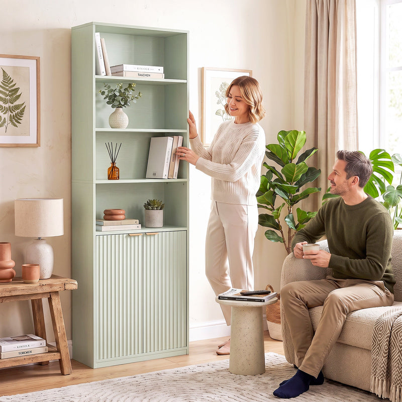 Couple in a living room with the light green bookcase against the wall
