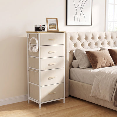 Beige fabric chest of drawers with headphones on the side hook beside a bed