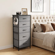 Chest of drawers next to a bed with a framed print and camera on top, shown in grey