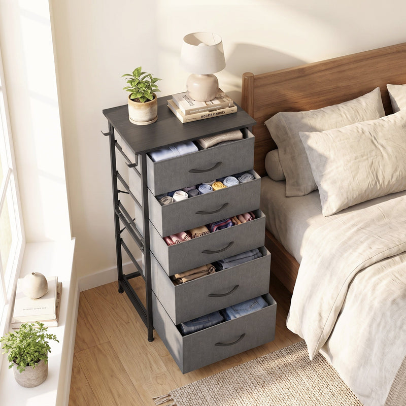 Chest of drawers by a window next to a bed with drawers pulled open, shown in grey