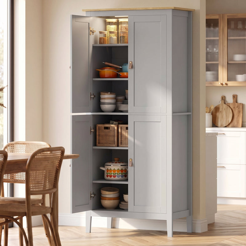 Grey pantry cupboard with open doors showing lit, stocked shelves beside a dining table