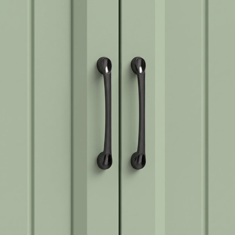 Close-up of the black handles on the sage green beadboard cupboard doors