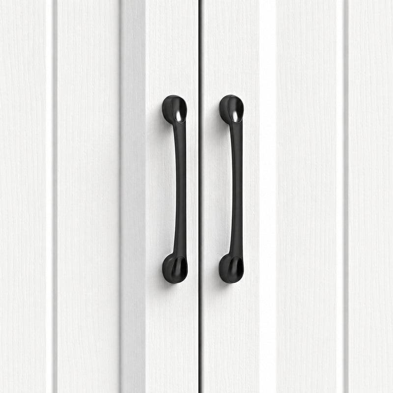 Close-up of the black handles on the white beadboard cupboard doors