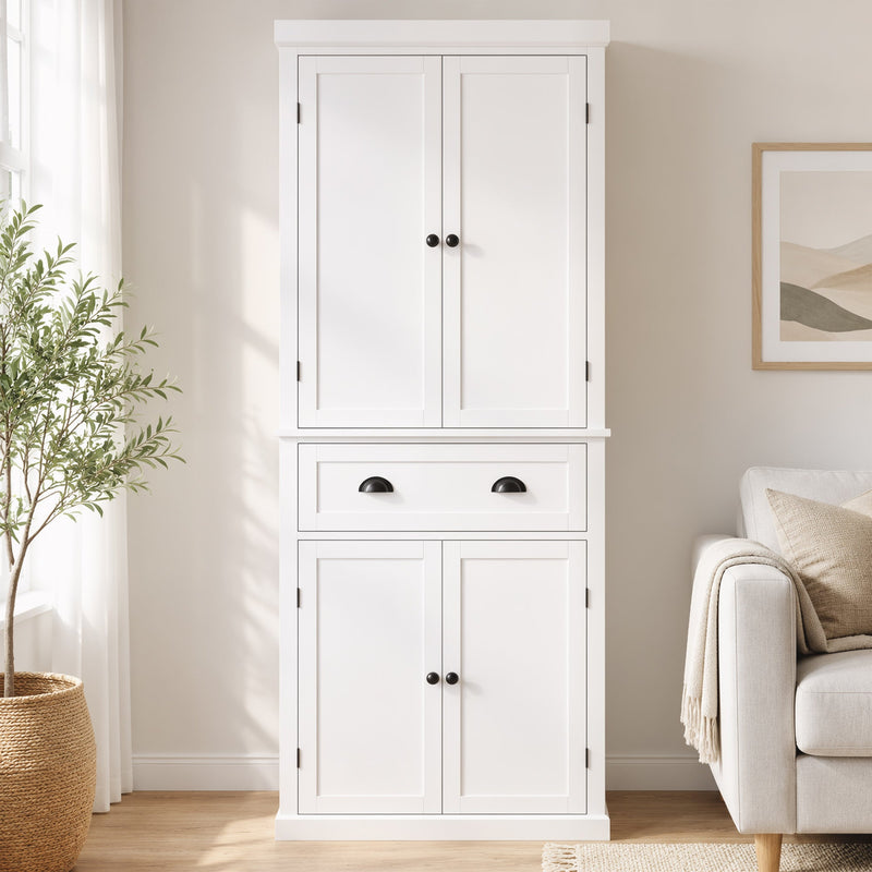 White kitchen cupboard styled beside a sofa in a living room setting