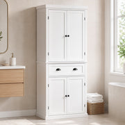 White kitchen cupboard styled in a bathroom beside towels and a mirror