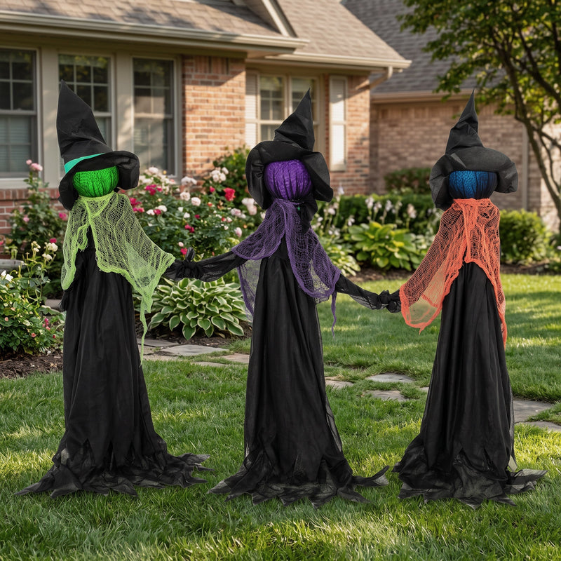 Three witches holding hands staged on a front lawn beside a house