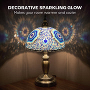 Table lamp glowing warmly in a dark room with light patterns on the wall either side