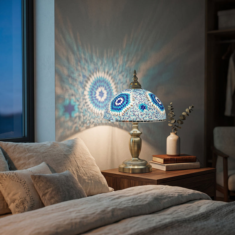 Lit table lamp on a bedroom nightstand beside a bed with linen bedding