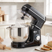 Stand mixer whisking in a kitchen beside bread and a rolling pin