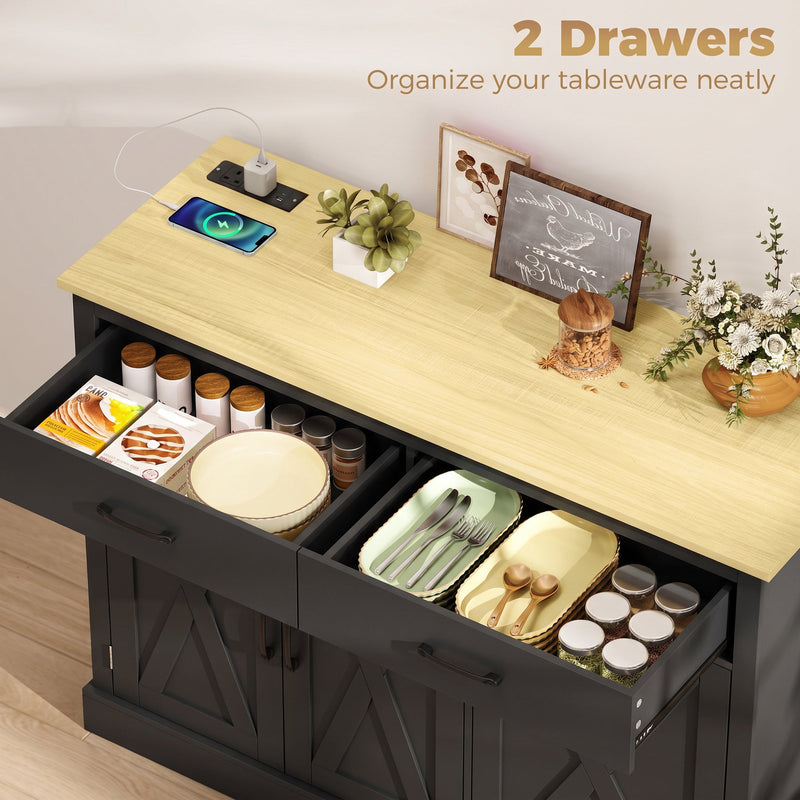 Open drawers of the black cabinet storing plates, cutlery trays and spice jars on the worktop
