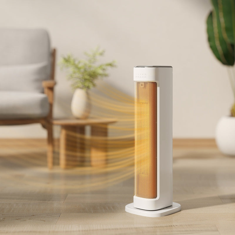 White tower heater with glowing warm air in a living room beside a chair