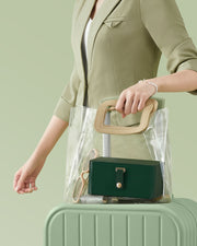 Woman holding a clear tote bag on a suitcase with the forest green jewellery case packed inside