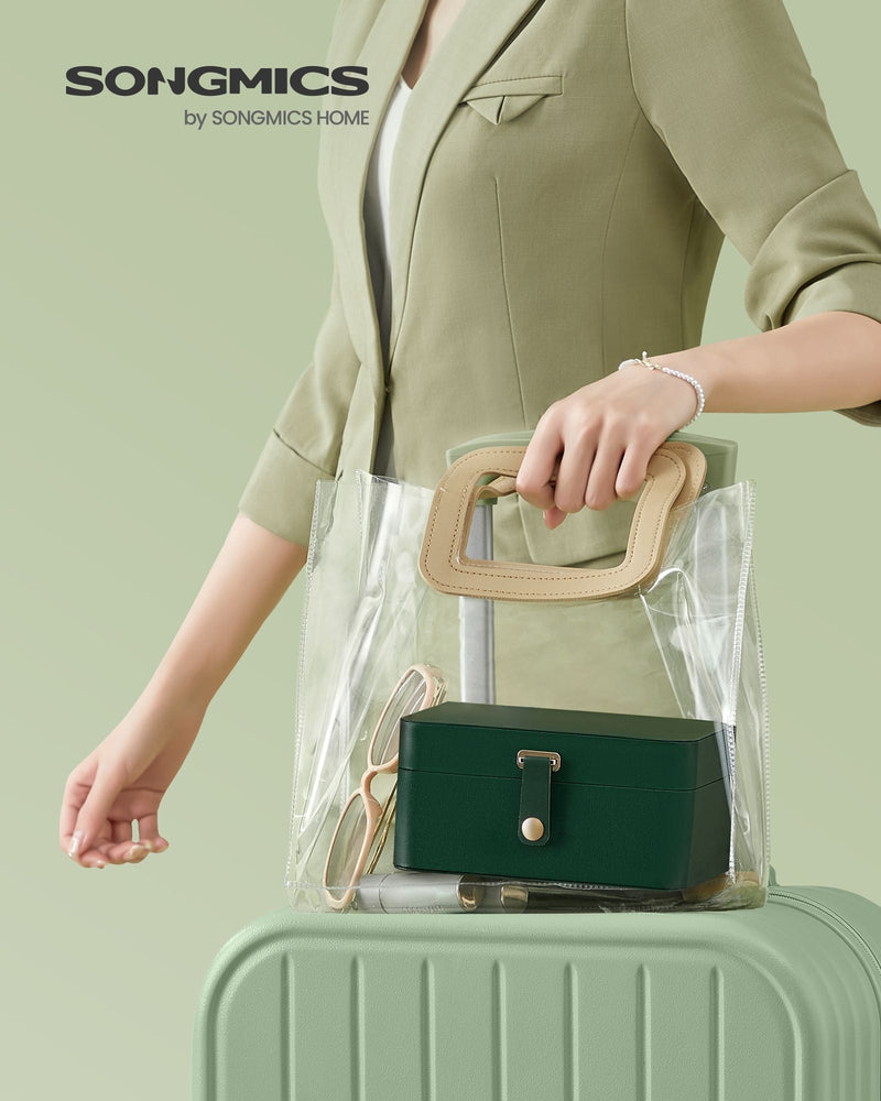 Songmics branded photo of the forest green jewellery case in a clear tote bag on a suitcase
