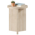 Travertine beige small round side table with a Y-shaped base, topped with a plant and books