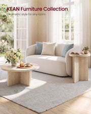 Round side table next to a sofa with cushions in a bright living room