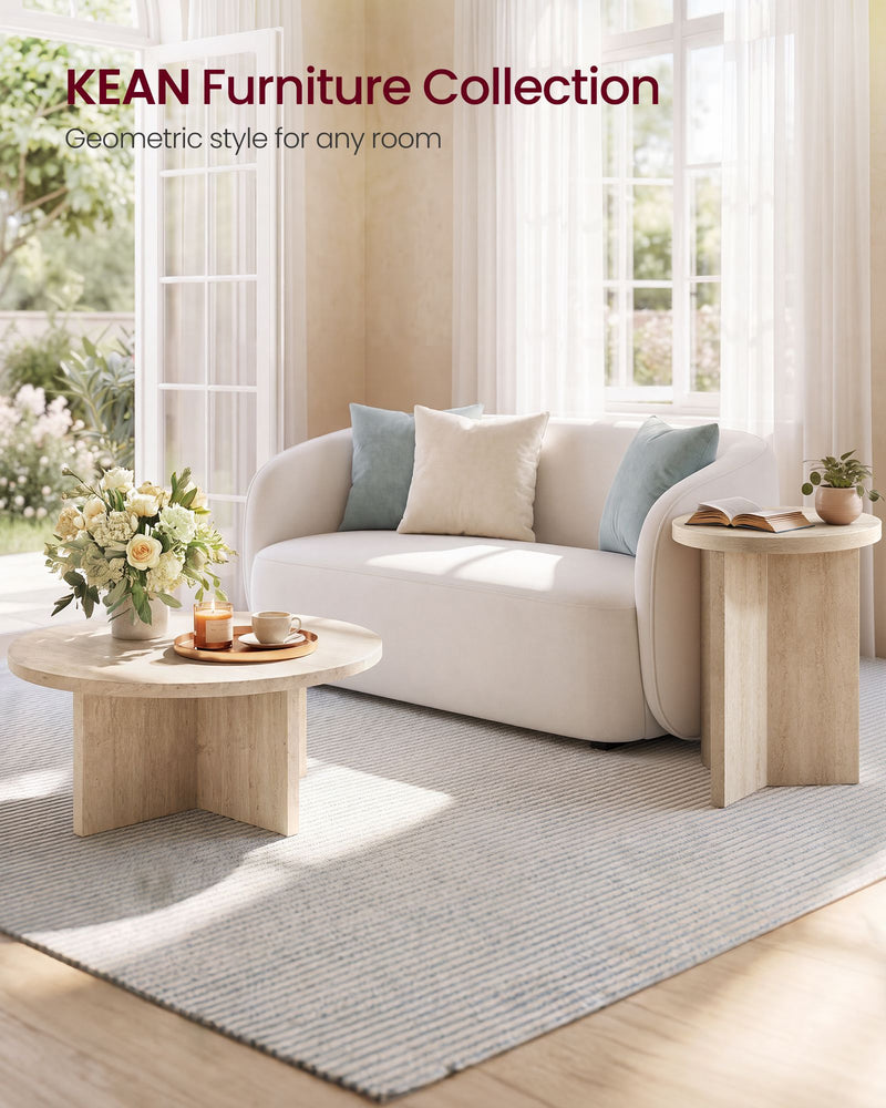 Round side table next to a sofa with cushions in a bright living room
