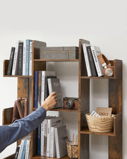 Person reaching in to take a book from a central shelf of the bookshelf