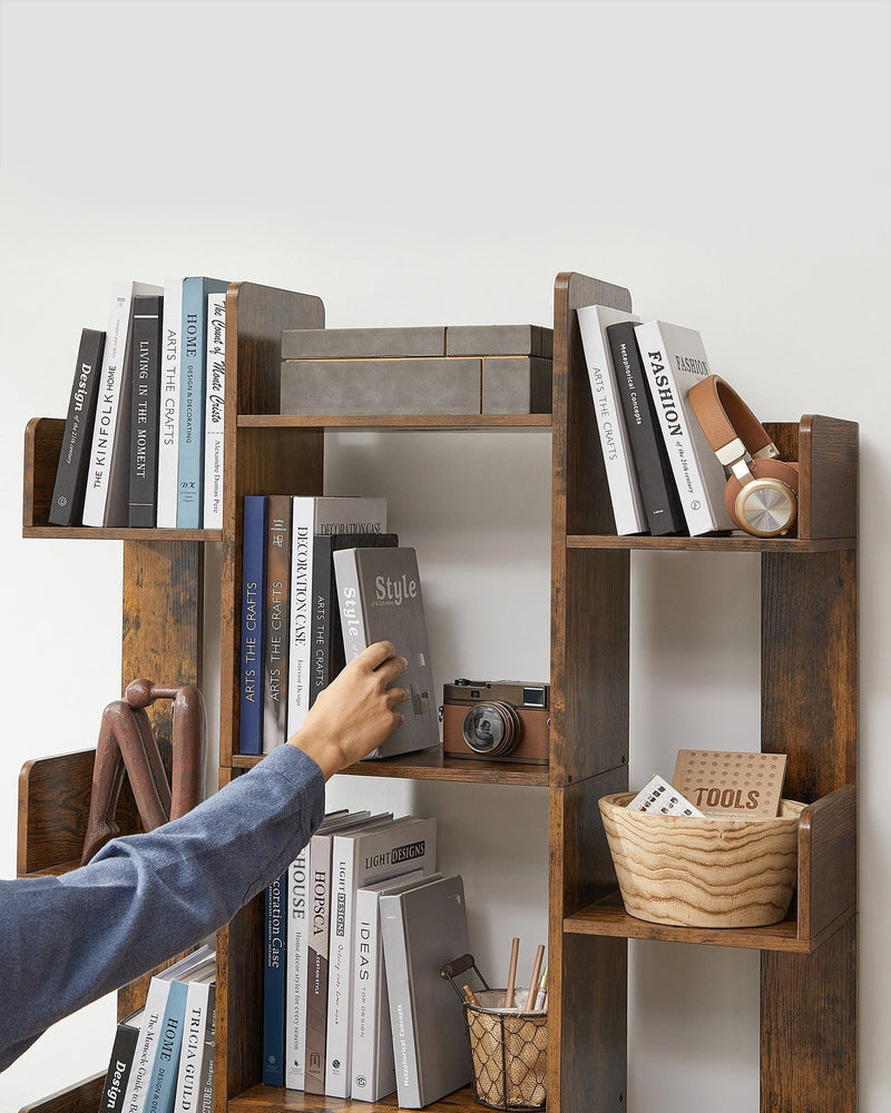 Person reaching in to take a book from a central shelf of the bookshelf