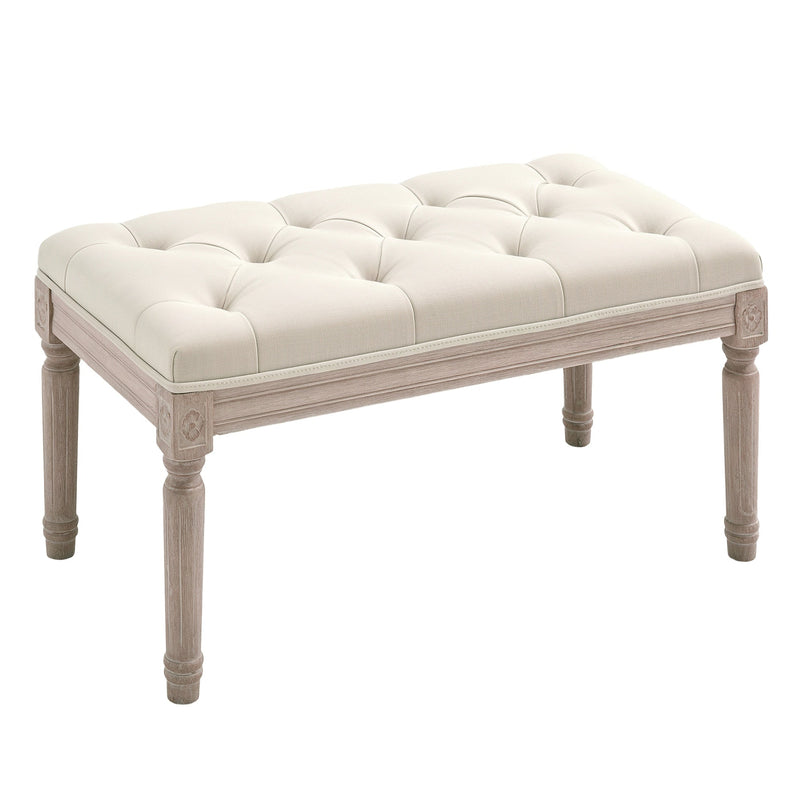 Cream white button-tufted bench with distressed wooden legs on a white background