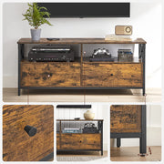 TV stand beneath a soundbar holding media players, a wooden radio and a plant against a white wall