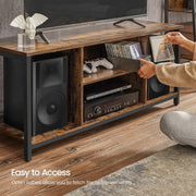 Hand reaching into an open cube to lift out a media case beside a games console