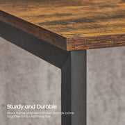 Close-up of the rustic brown tabletop edge meeting a black steel leg