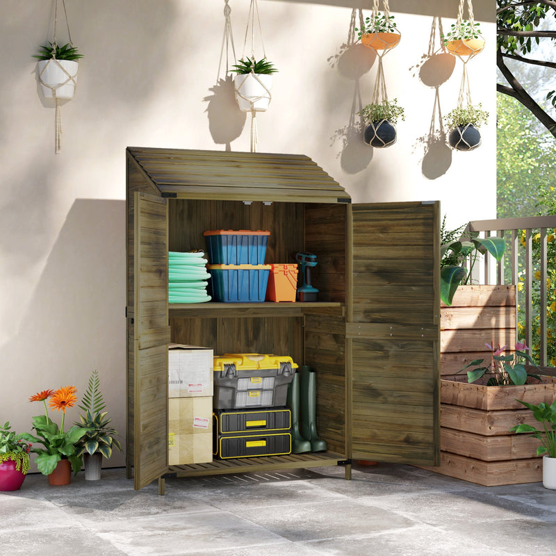 Green wooden shed open on a patio with hose reels, storage tubs, a toolbox and wellington boots inside