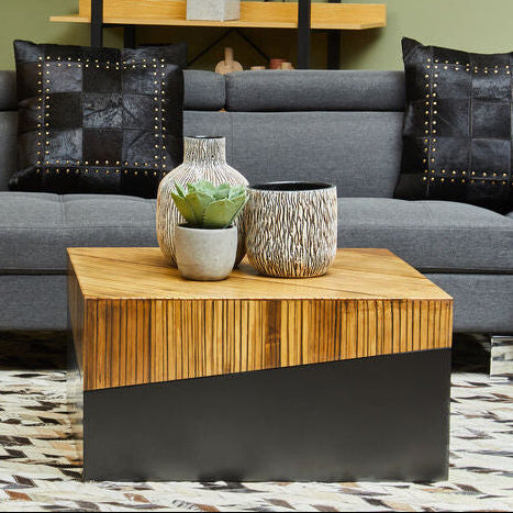 Two-tone bamboo and black square coffee table styled in front of a sofa