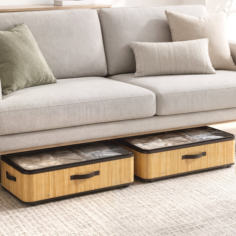 Two under bed storage boxes tucked beneath a grey sofa with cushions