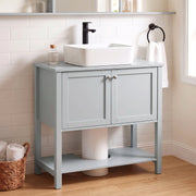 Light Blue under sink cabinet below a vessel sink in a tiled bathroom with a round mirror