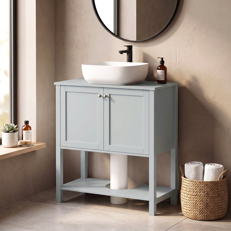Light Blue under sink cabinet beside a window with a vessel sink and towels on the lower shelf