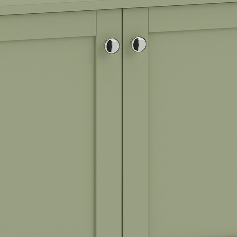 Close-up of the silver-tone round handles on the green cabinet doors