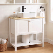 White under sink cabinet below a vessel sink in a tiled bathroom with a round mirror