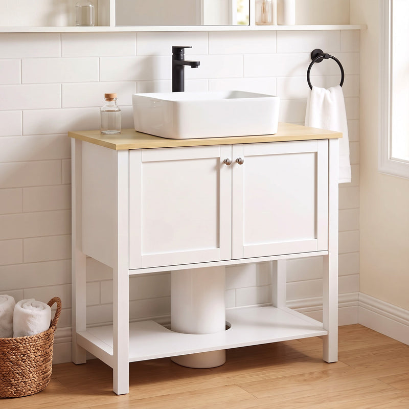 White under sink cabinet below a vessel sink in a tiled bathroom with a round mirror