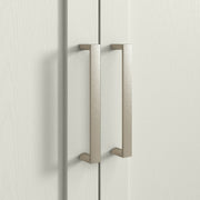 Close-up of a metal door handle on the cream arched cabinet door