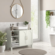 Cream under sink cabinet below a vessel sink in a bathroom with a round hanging mirror