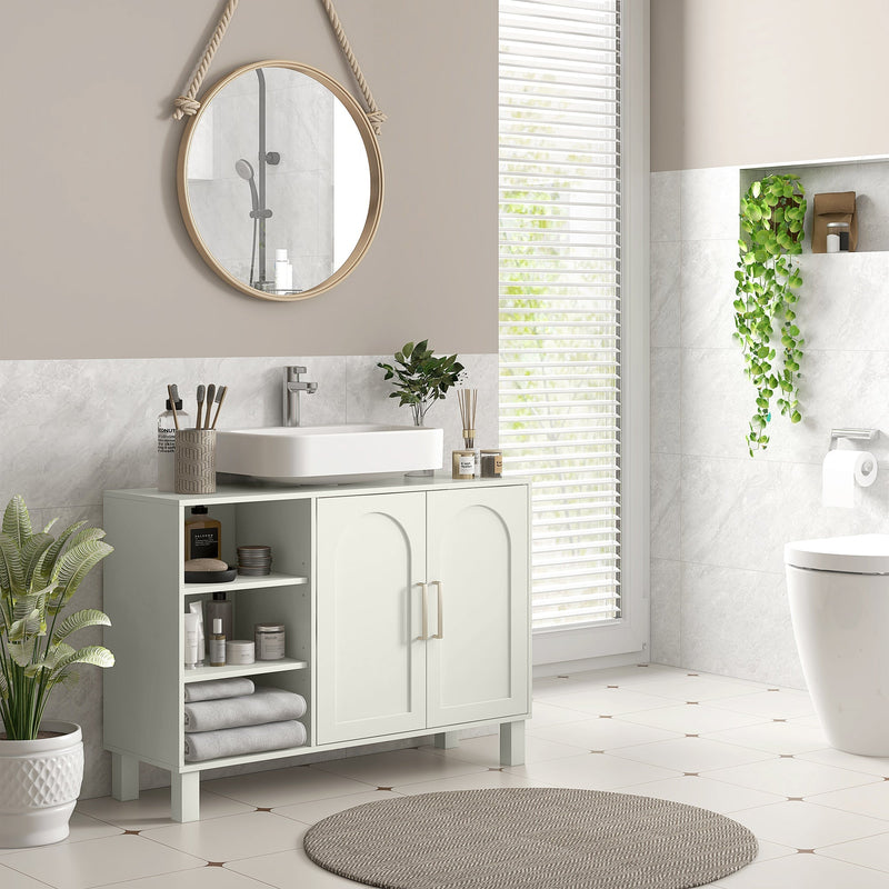 Cream under sink cabinet below a vessel sink in a bathroom with a round hanging mirror