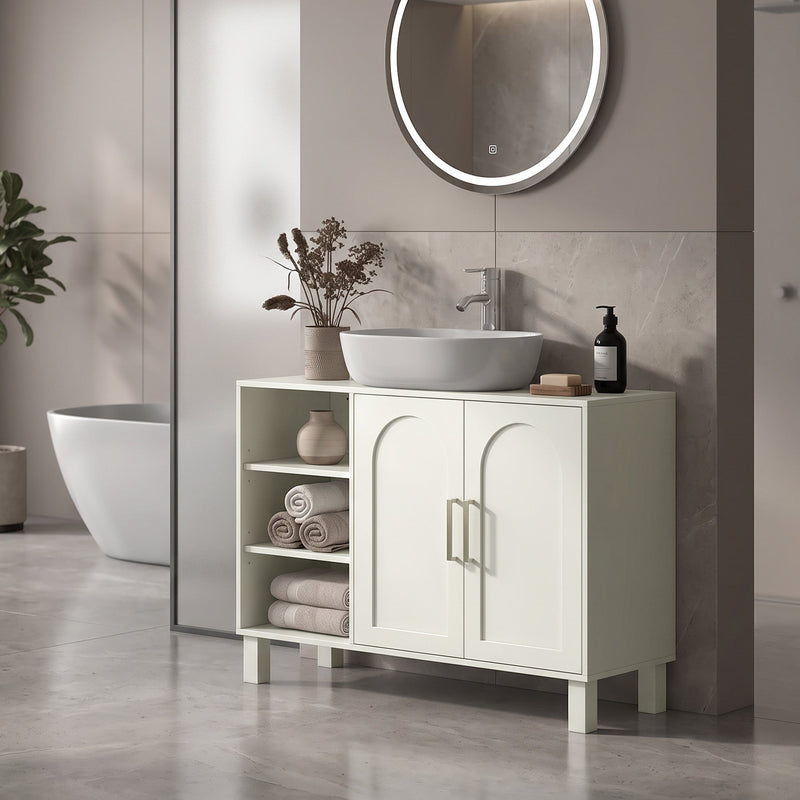 Cream under sink cabinet under a vessel sink with towels on the open side shelves