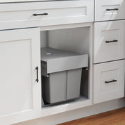 Pull-out bin fitted inside a white kitchen cabinet below the worktop
