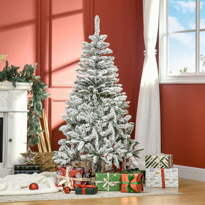 Snow flocked Christmas tree in a red living room beside a window and wrapped presents