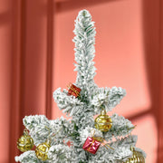 Close-up of the flocked tree top decorated with baubles and small gift ornaments