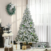 Flocked tree decorated with baubles and a wreath in a living room beside a window